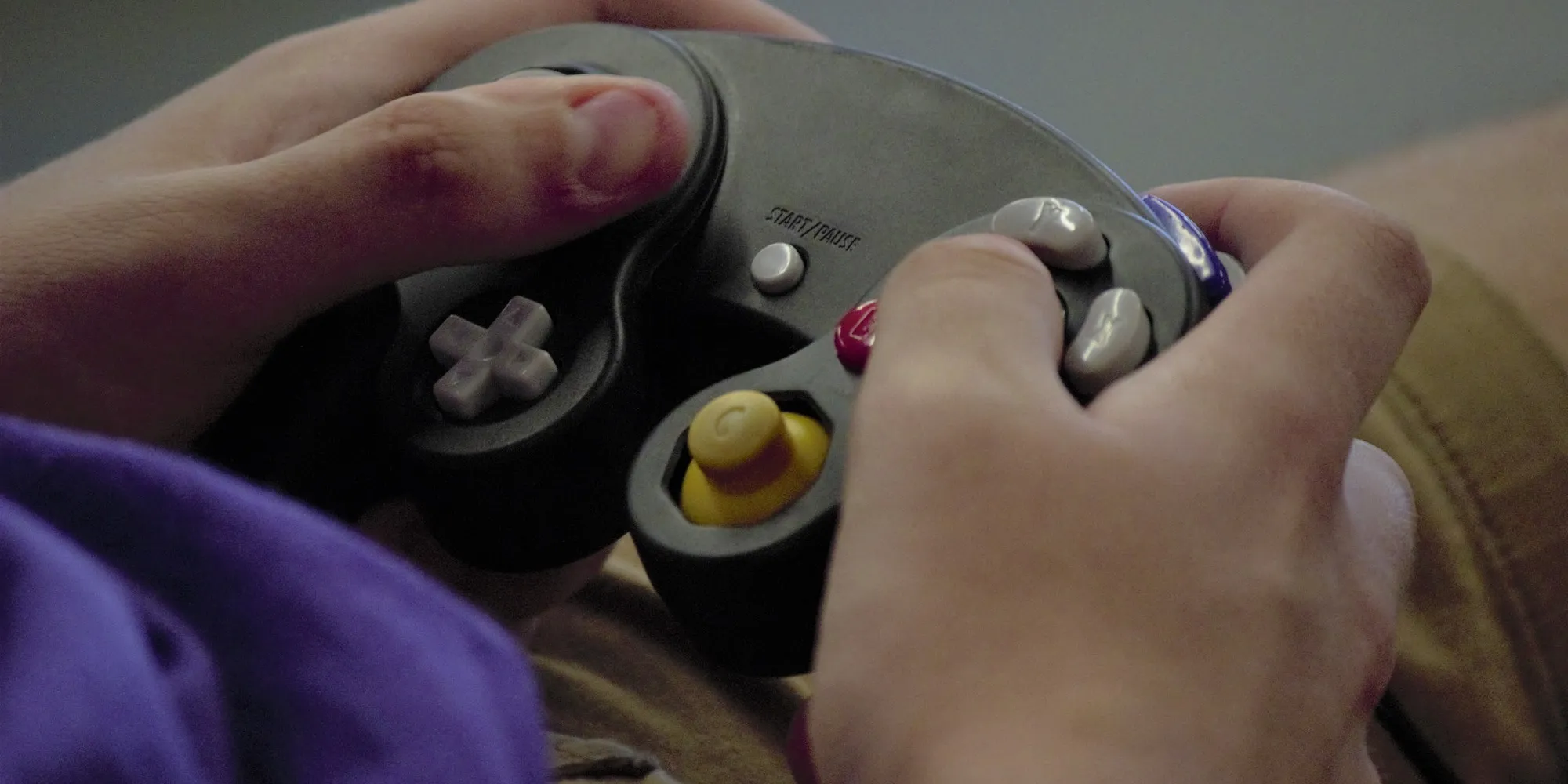 In Use image of Real photo of someone playing with the Nintendo GameCube, hands on the controller with the console visible